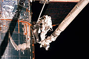 Astronauts Lee and Smith repairing parts of Hubble's insulation.