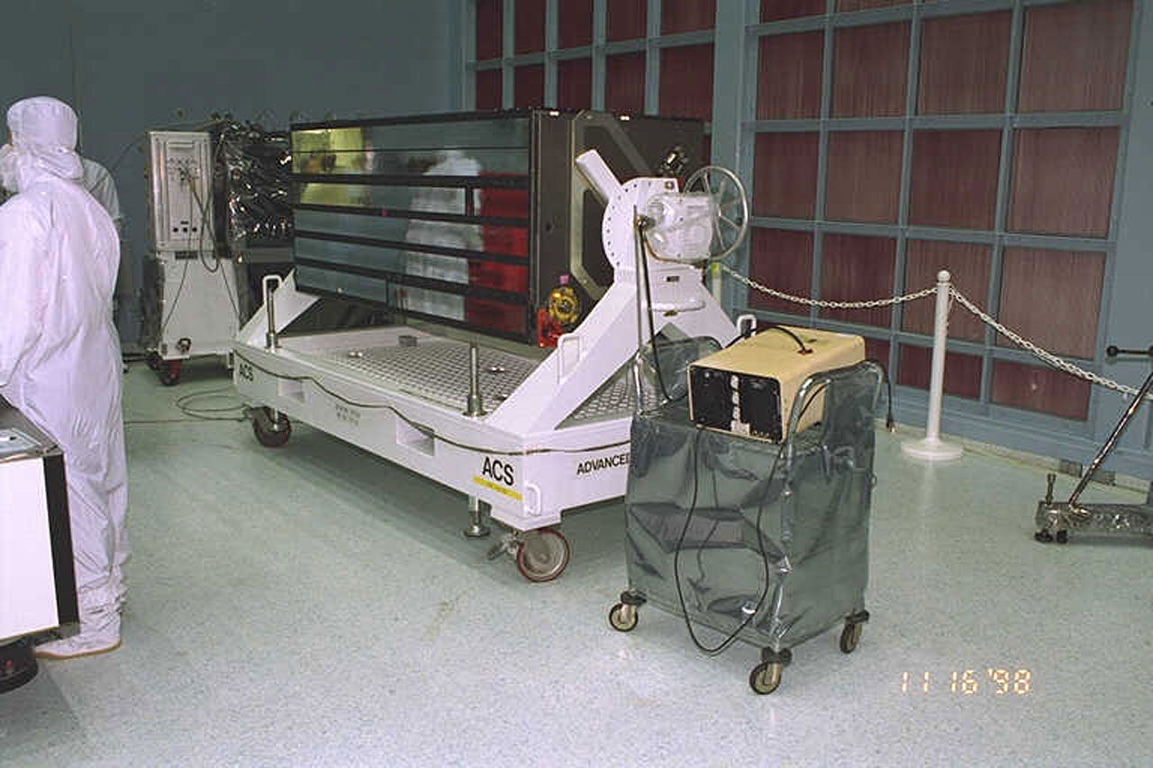 Technicians working with the ACS instrument in a clean room environment.